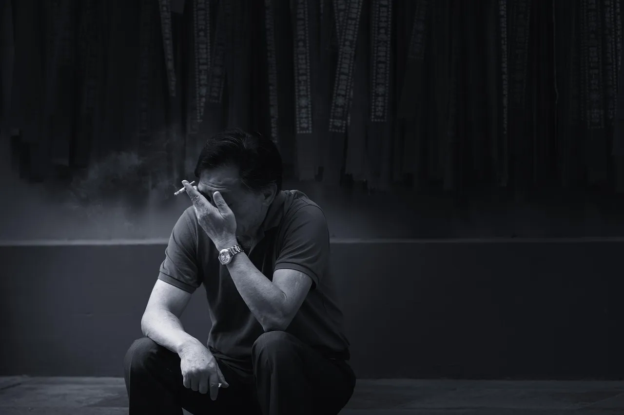 야간뇨 원인과 전립선 비대증 증상으로 잠 못 이루고 고민하며 담배 피우는 중년 남성